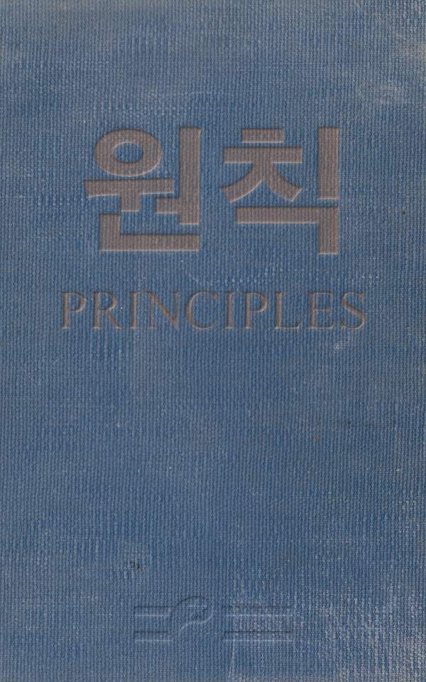 This image is the front cover of the book titled 'Principles', the title word ending P-L-E-S as in "The principles of a particular theory or philosophy". The book is bound in battered and sun-bleached blue cotton. Centered and in faded orange the Korean translation of the title is stamped, below which the title is stamped in English. In the lower middle is stamped what appears to be a variation on the 1945–1946 Flag of the People's Republic of Korea.